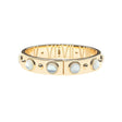 Gold hinge cuff bracelet features large mother of pearl cabochons on the outside, and then roman numerals with star details inside