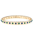 Thin gold hinge cuff features lapis and malachite stones on the outside and the phrase "the days are long but the years are short" inscribed on the inside