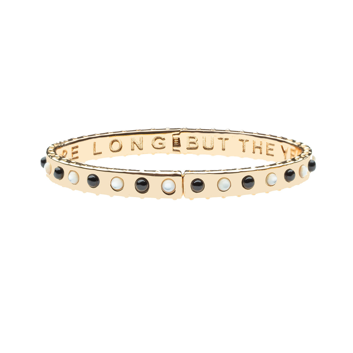 Thin gold hinge cuff features onyx and mother of pearl stones on the outside and the phrase "the days are long but the years are short" inscribed on the inside
