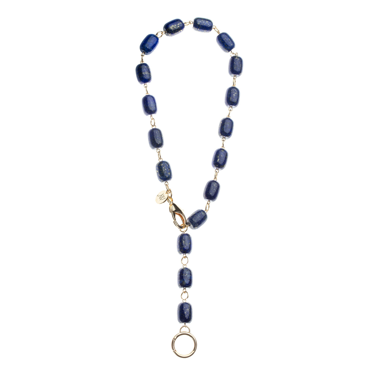 Necklace features chunky lapis beads with oversize gold lobster clasp and ring to attach pendants. Shown as a lariat.