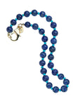 Beaded necklace features large carved lapis beads with small turquoise beads in between. Necklace has oversized gold lobster clasp