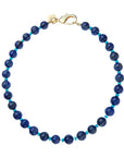 Beaded necklace features large carved lapis beads with small turquoise beads in between. Necklace has oversized gold lobster clasp