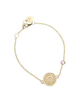 Gold chain bracelet featuring mini coin with moon and star logo and the words LOVE, COURAGE, and STRENGTH with pink tourmaline accent on chain
