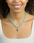 Model wearing the strong keep swimming beaded necklace