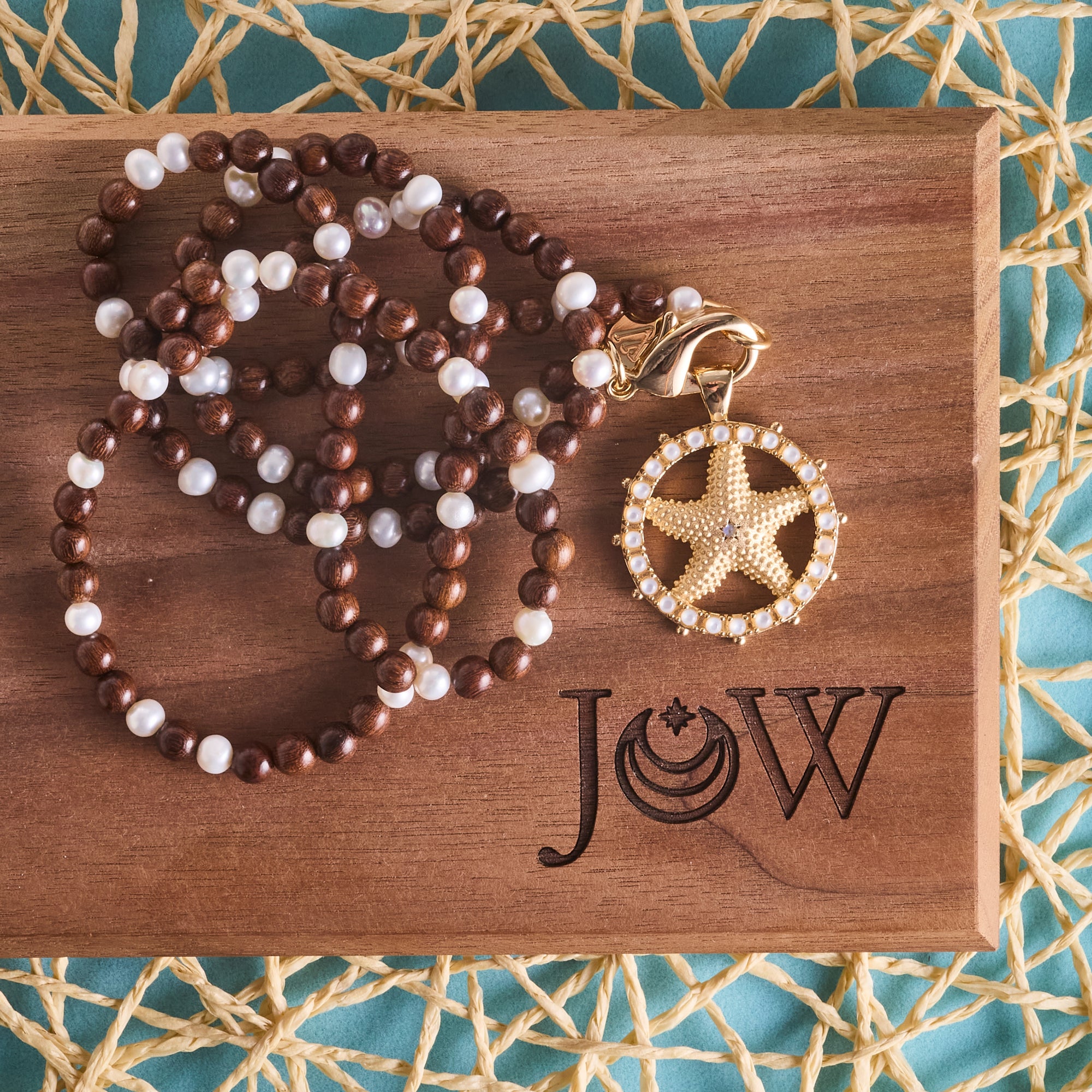 Stylized shot of the strong light of the ocean pendant with the wood and pearl double wrap chain