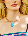Model wearing the carved turquoise shell on the embellished neck cuff