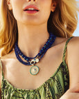 Model wearing the strong day break pendant with various lapis beaded necklaces