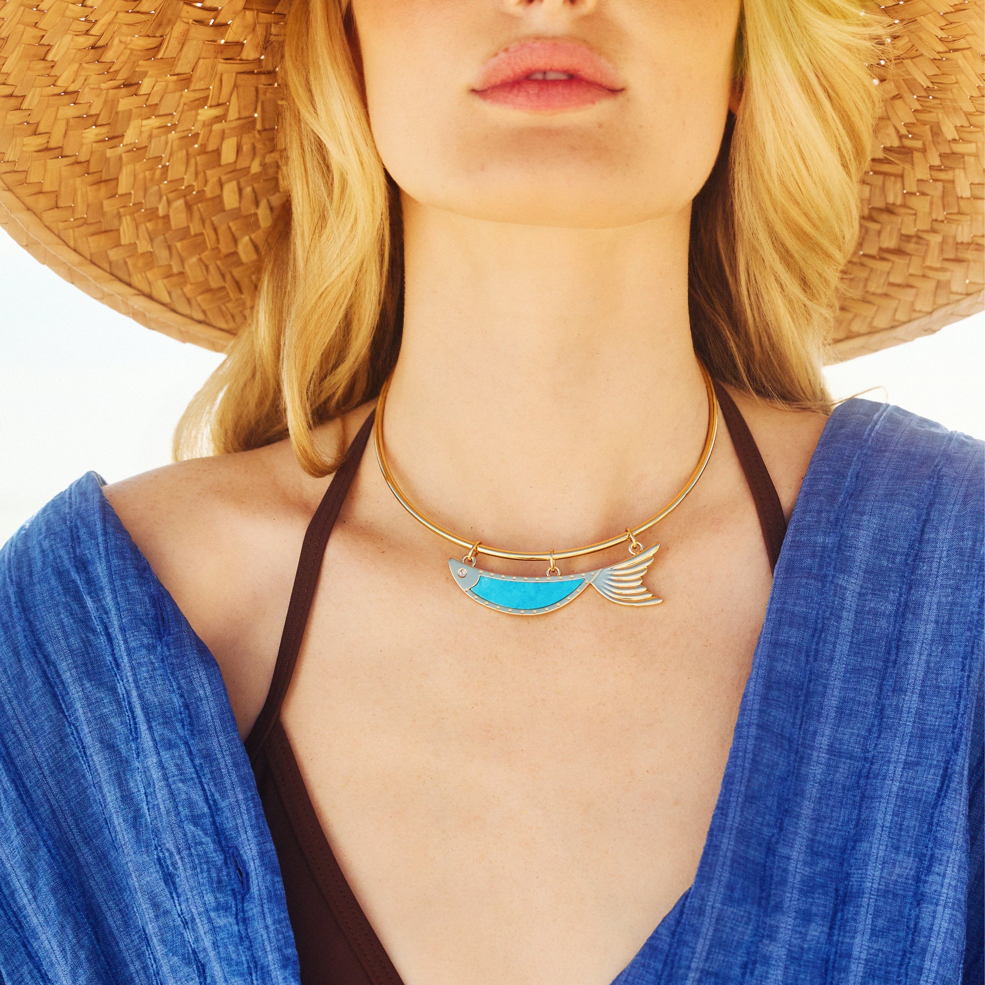 Model wearing the keep swimming fish in turquoise on the neck cuff