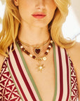 Model wearing the love dolce heart on the gold neck cuff and the strong supernova pendant on the wood and pearl statement necklace.