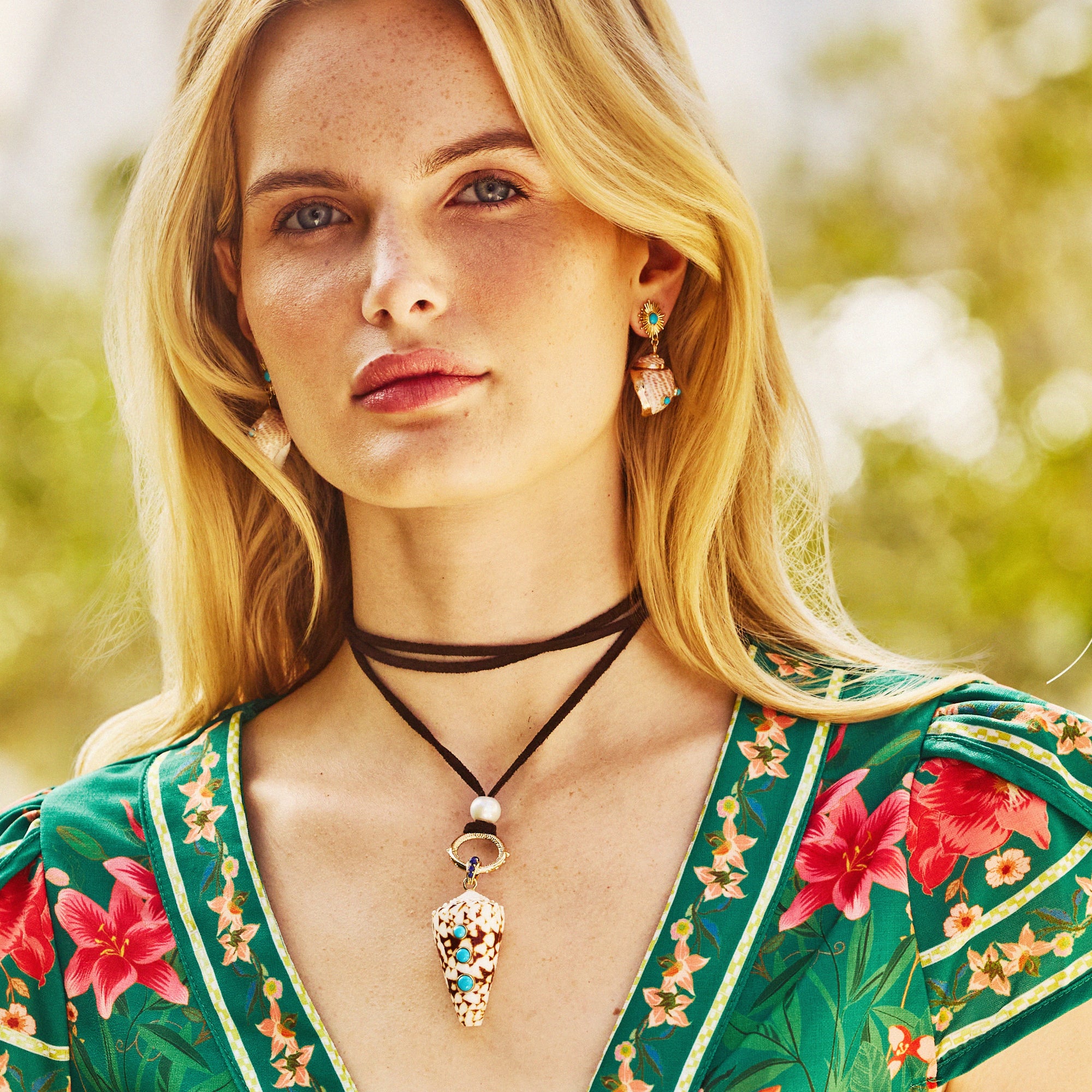 Model wearing the leather lariat with the strong in the shallows shell pendant, as well as the strong soaking up the sun earrings