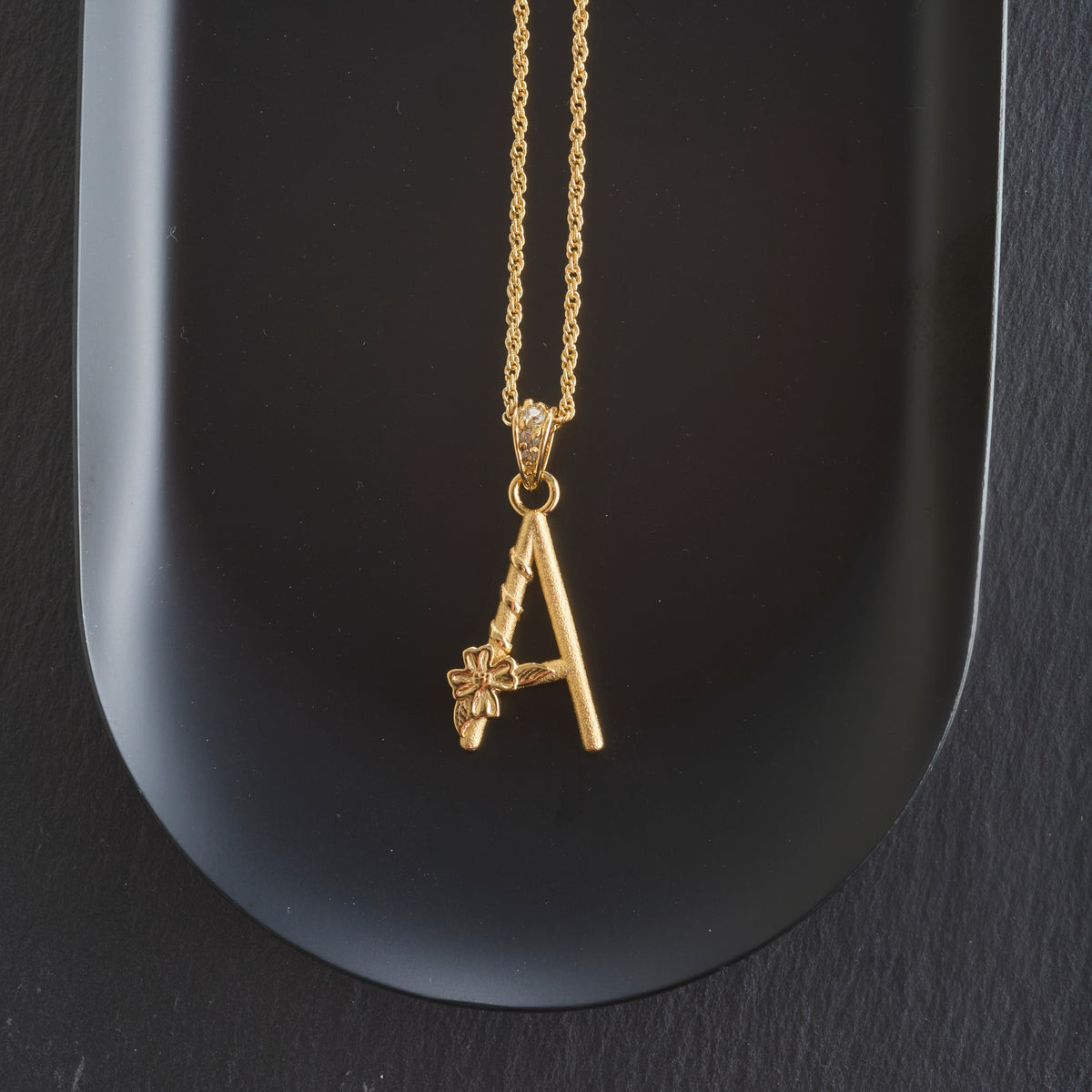 Stylized shot of the dogwood letter A on the classic rolo chain