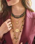 Model wearing various pendants and chains from the protect collection