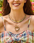 Model wearing the love you to the moon and back heart, made from love tennis necklace, and herringbone chain