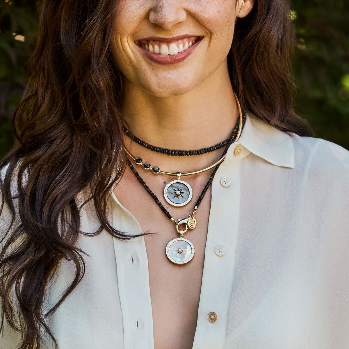 Model wearing the forever carved sundial in black mother of pearl on the black mother of pearl embellished neck cuff and the carved sundial in mother of pearl on the black agate double wrap
