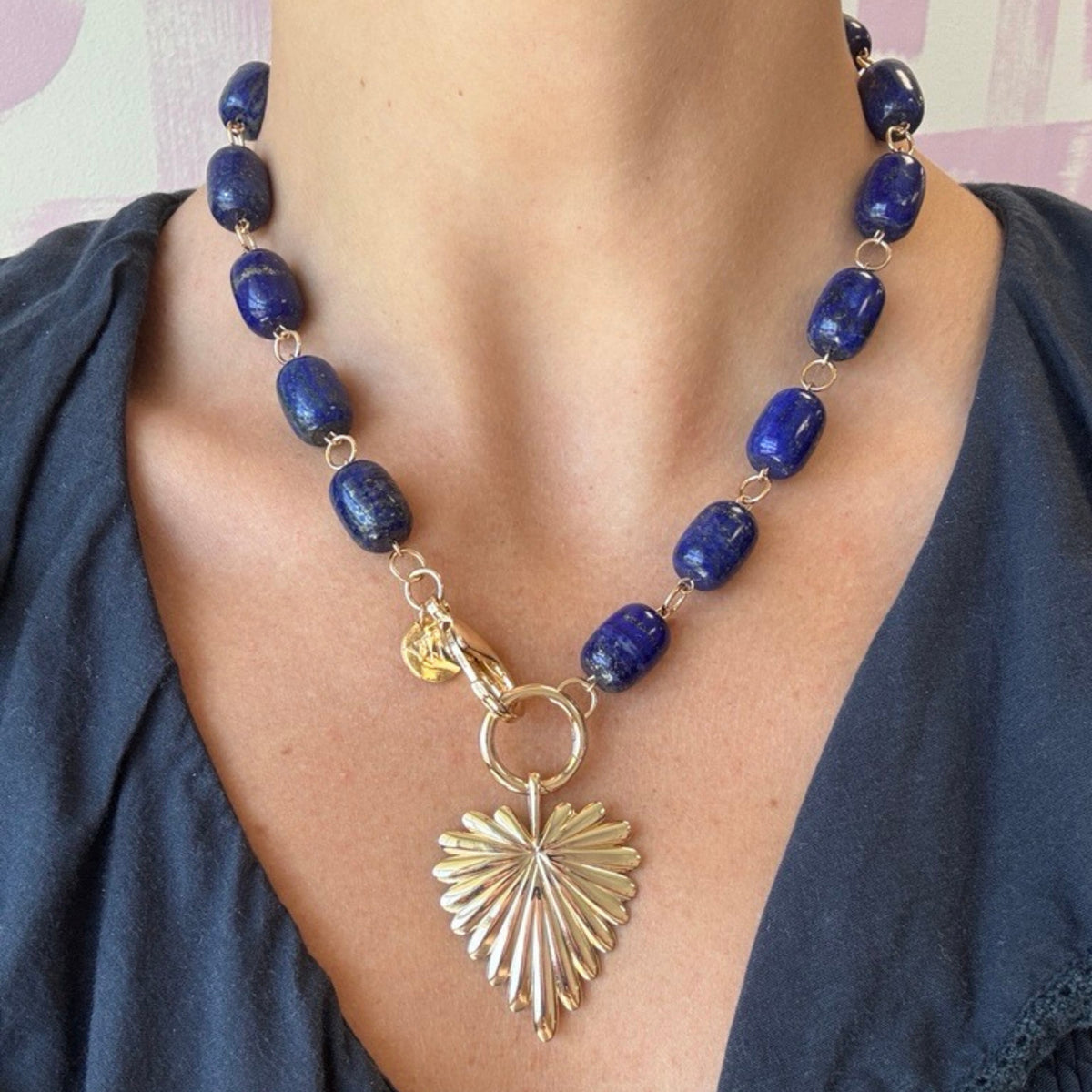 Model wearing the chunky lapis lariat shown at full length with the full heart pendant