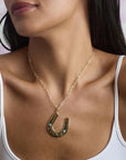 Model wearing the jumbo lucky horseshoe pendant on the drawn link chain