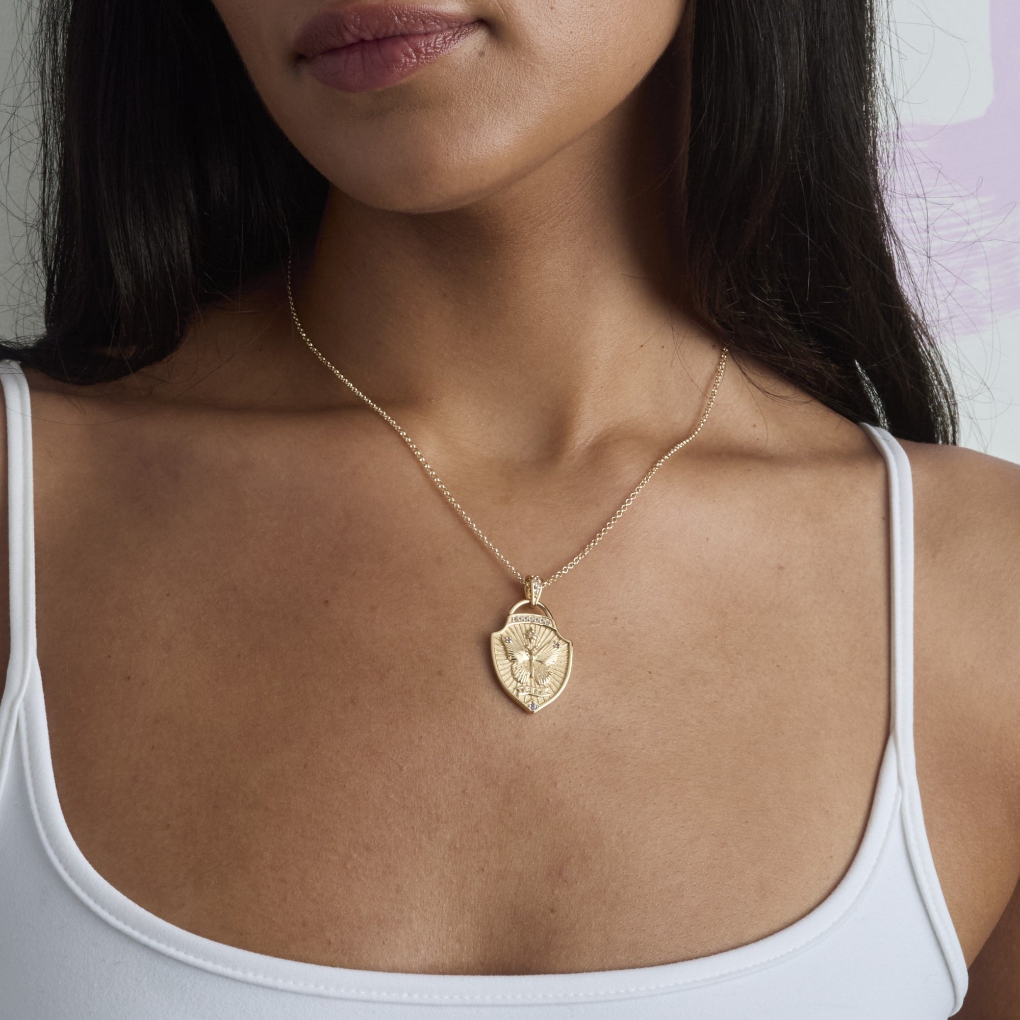 Model wearing the free shield pendant on the classic rolo chain
