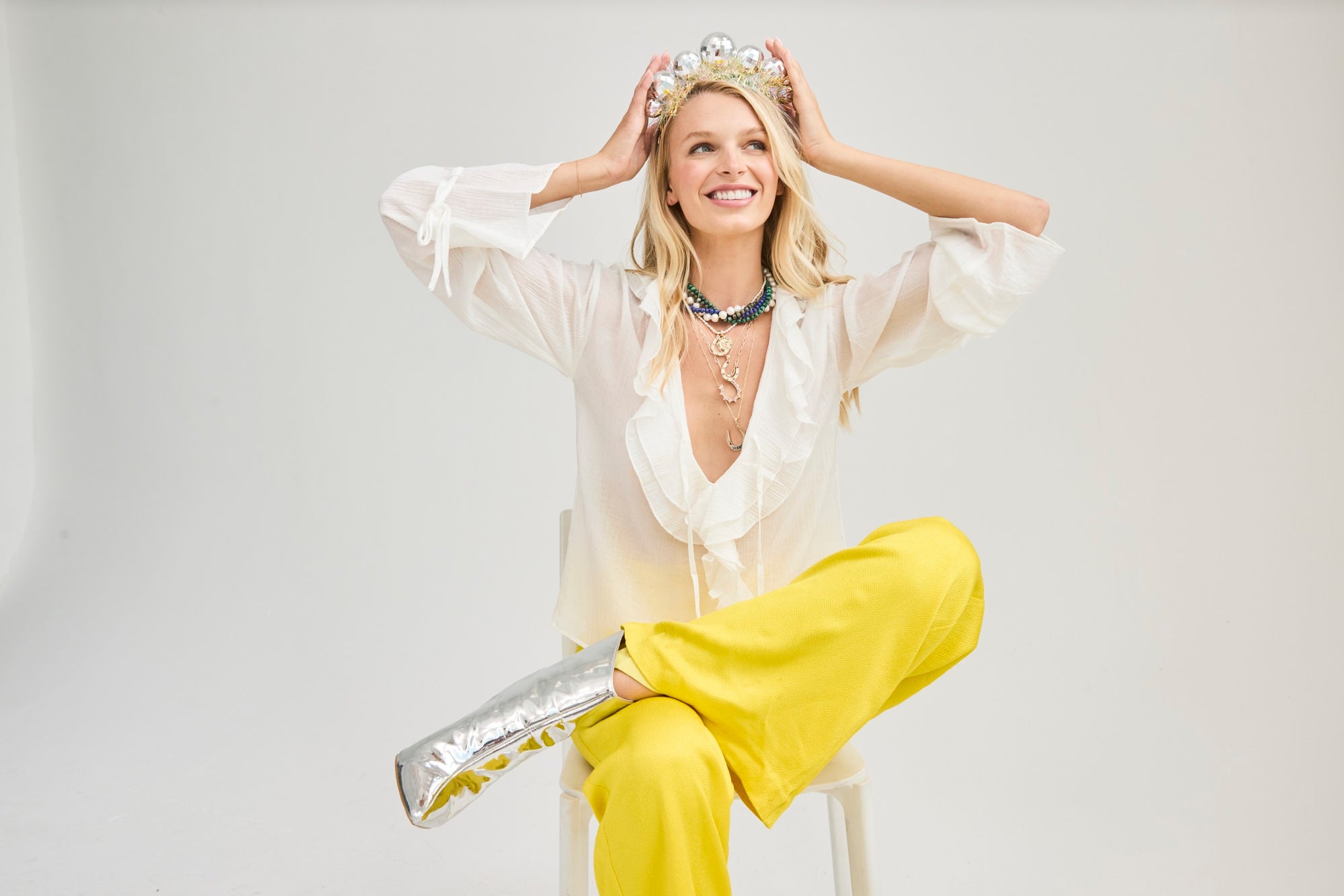 Jane Win model wearing a crown and jewelry and yellow pants with words New Years Cheer Sale Up To 50% Off