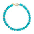 Beaded necklace features chunky turquoise beads with flat gold beads mixed in and oversized gold lobster clasp