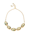 Slider bracelet features gold cowrie shells with turquoise cabochon accents