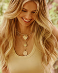 Model wearing assorted love, courage, and strength coins