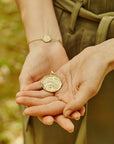 Model holding the love courage strength coin and wearing love courage strength bracelet