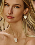 Model wearing the love from the heart earrings in mother of pearl