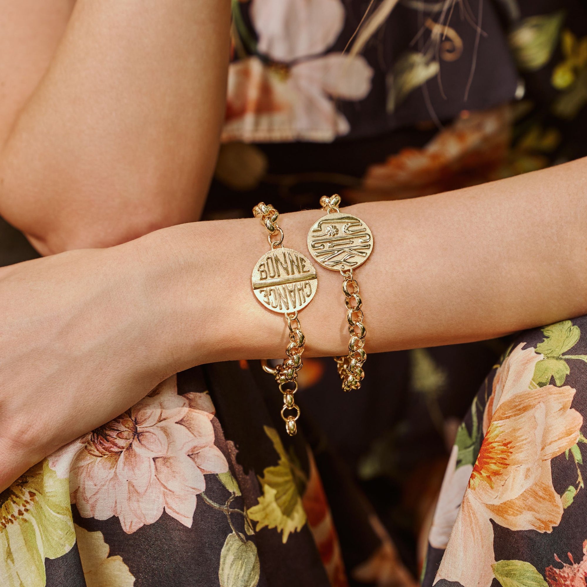 Model wearing 2 bonne chance bracelets to show each side of the coin