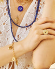 Model wearing various protect evil eye pendants, ring, and bracelet