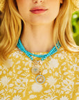 Model wearing forever sundial cutout and strong over the horizon coins on turquoise beaded chains