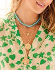 Model wearing various JOY necklace layers