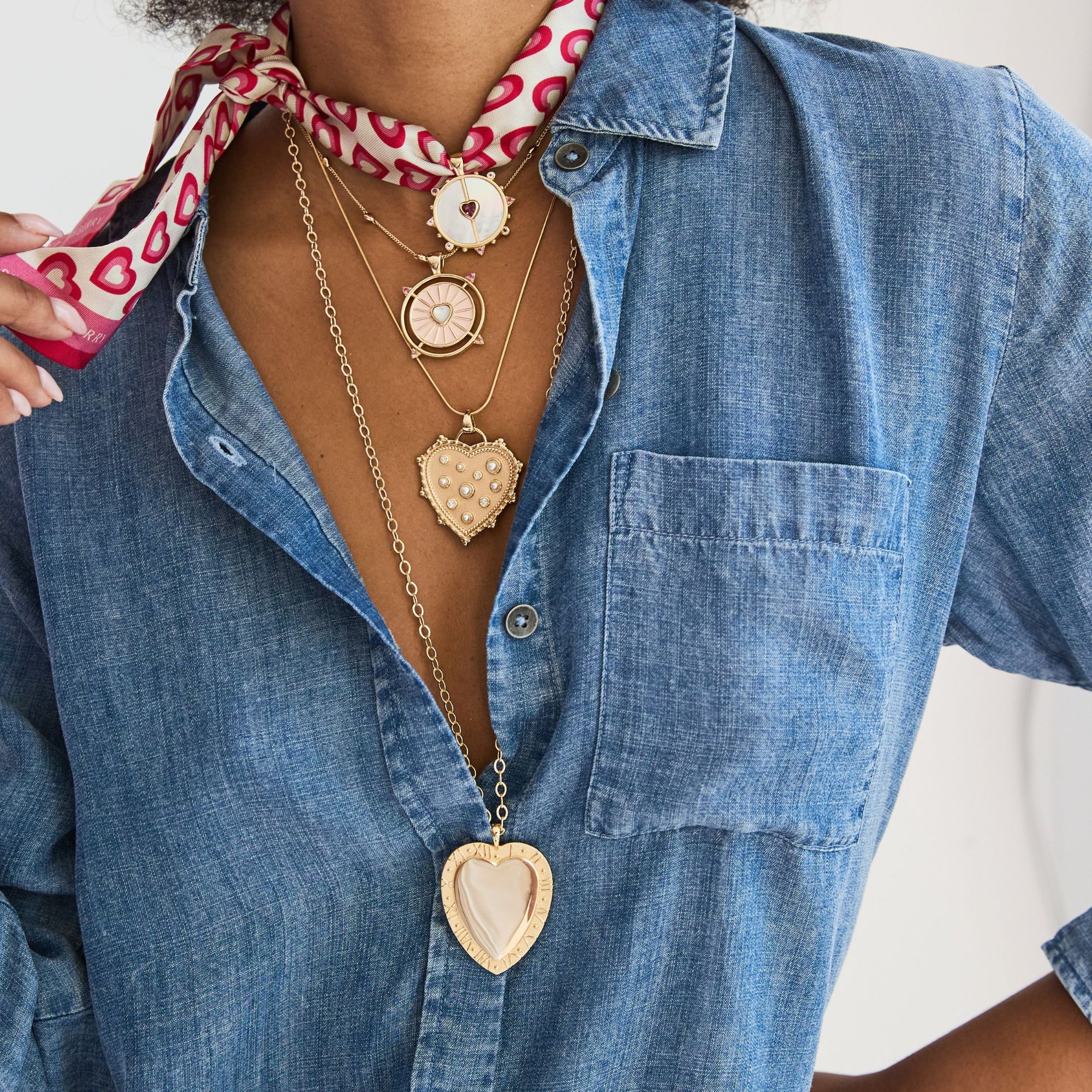 Woman wearing a denim shirt and four necklaces