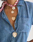 Woman wearing a denim shirt and four necklaces