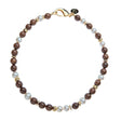 Beaded necklace featuring round wood and pearl beads with flat gold peads interspersed. Necklace features oversized gold lobster clasp