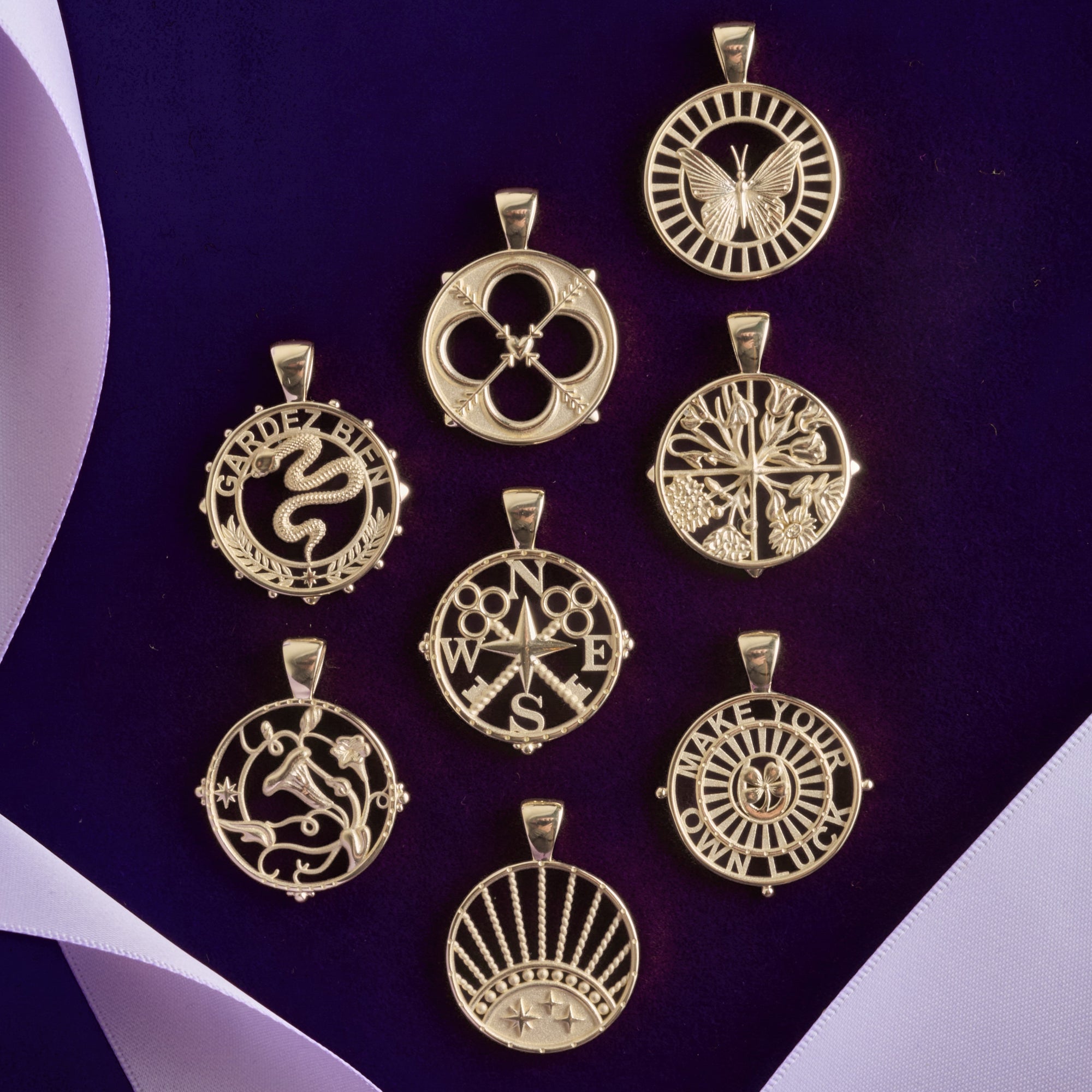 Stylized shot of all cutout coin pendants on dark purple background