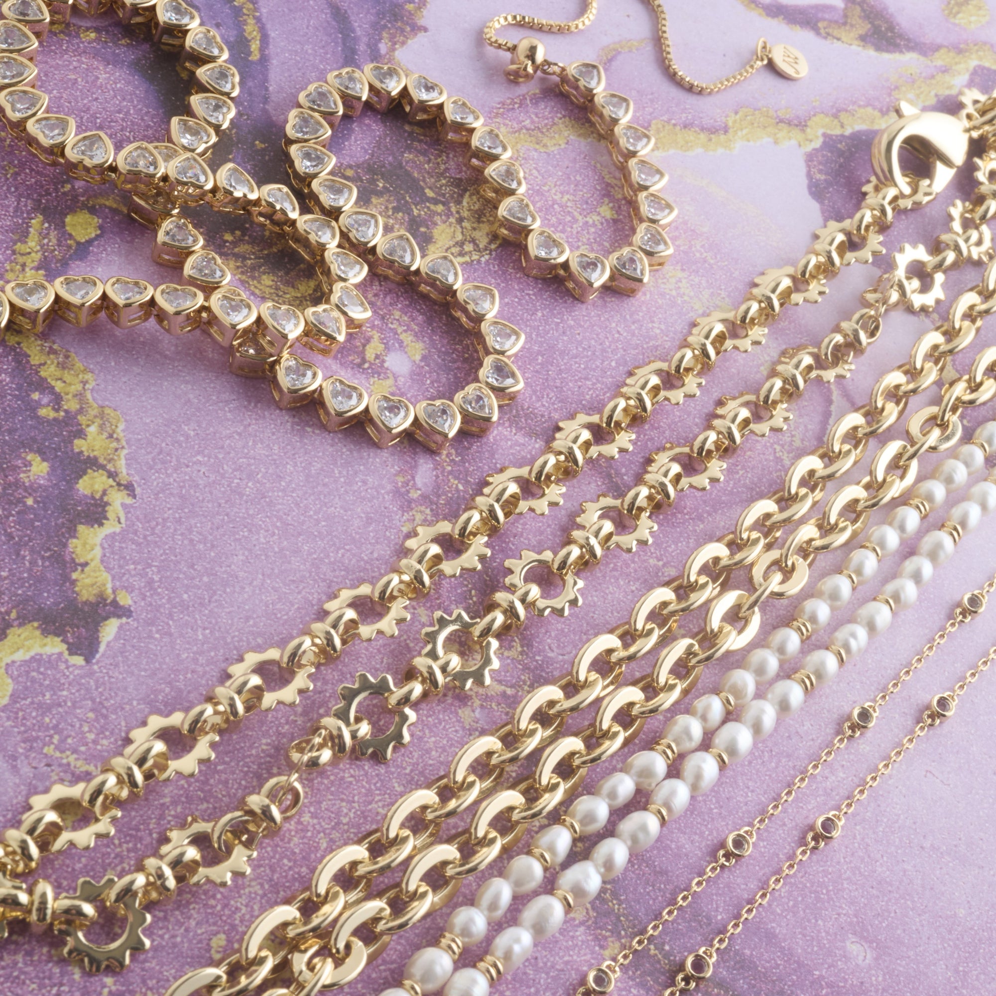 Stylized shot of assorted chain styles on purple background