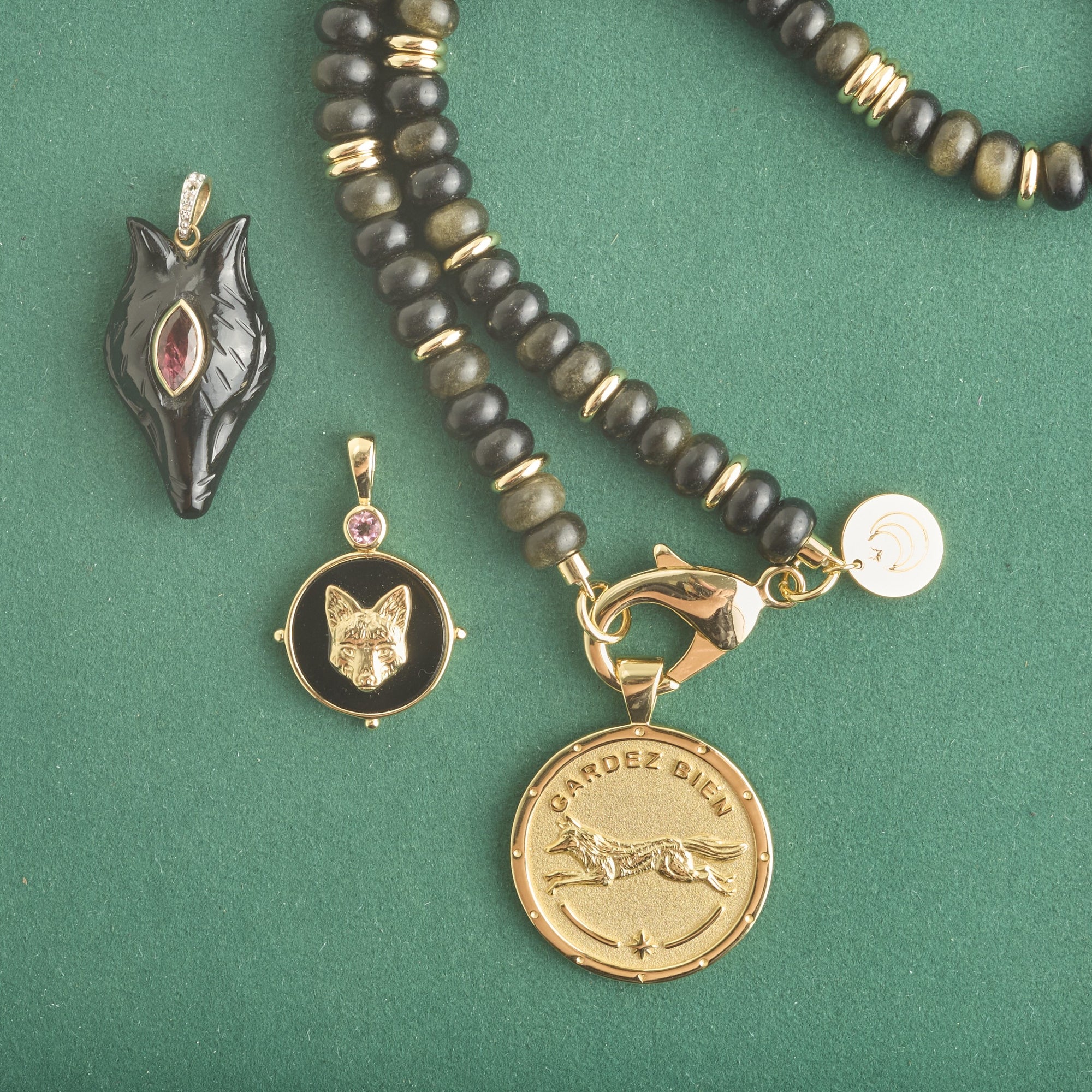 Stylized shot of fox pendants and obsidian beaded necklace