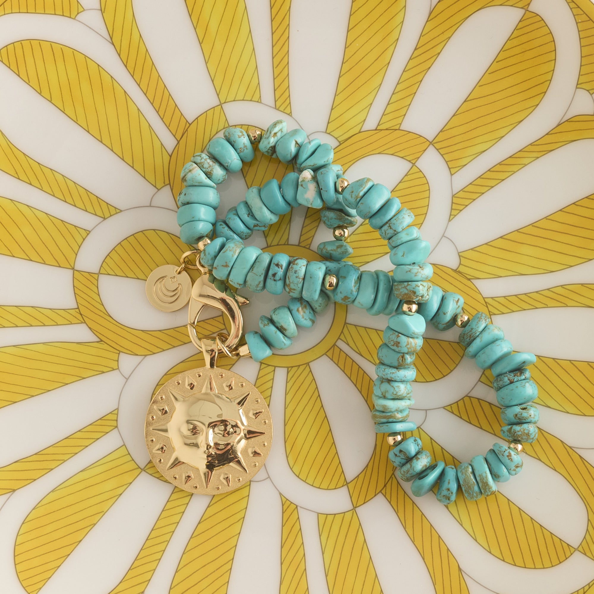 Stylized shot of beaded turquoise necklace with sun coin pendant